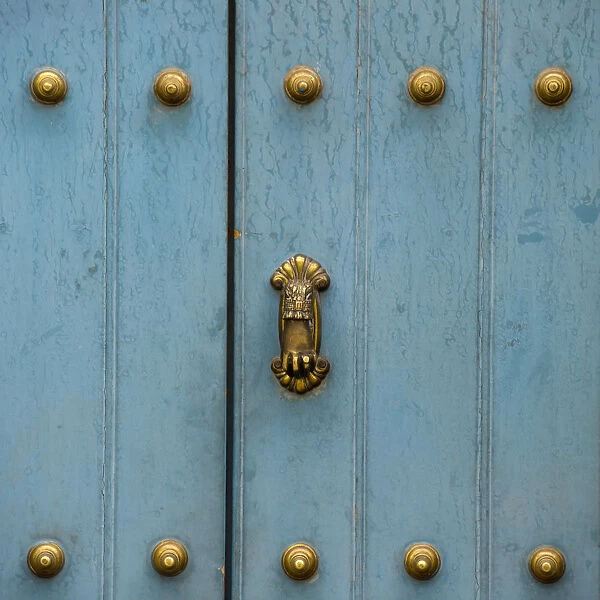A Blue Door With Brass Decorative Knobs
