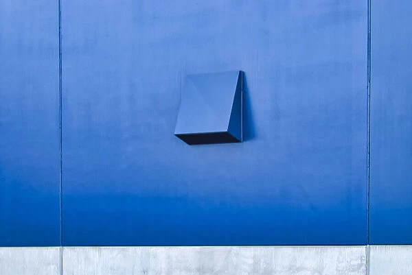 Blue Vent. A color photograph of an air duct the blue concrete wall of