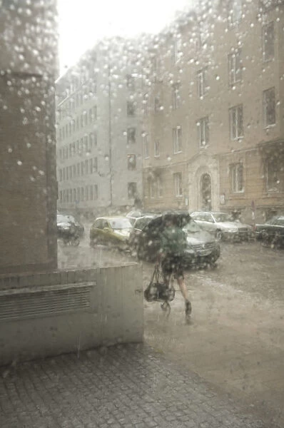 Blurred street atmosphere through a window pane with rain drops