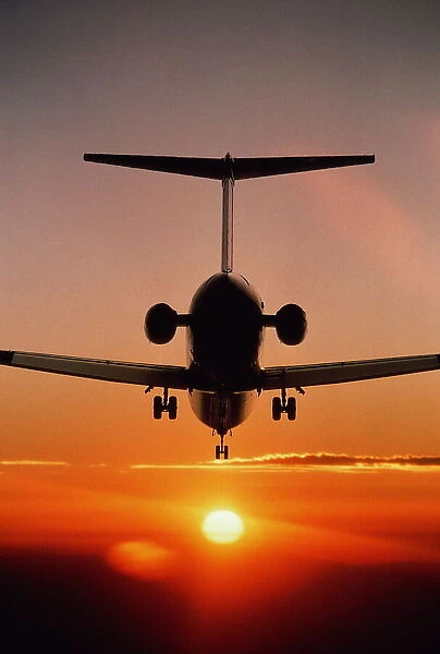 Boeing MD-80 airliner landing at sunset