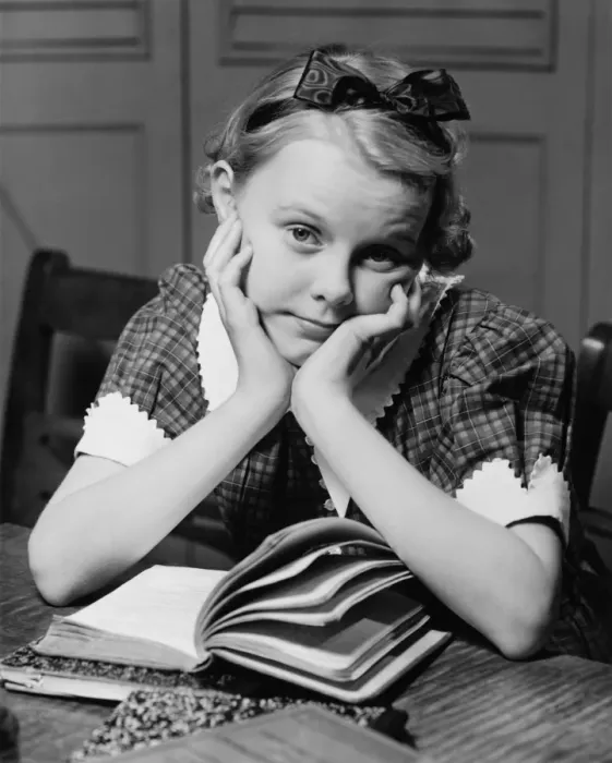 Framed Print : Bored young girl (12-13) at table with book, (B&W) Framed Print : Bored young girl (12-13) at table with book, (B&W)