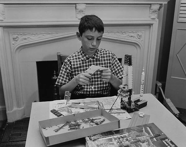 Boy (12-13) making space rocket model in living room