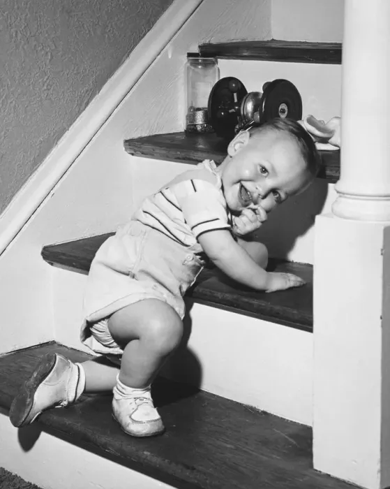 Framed Print : Boy (18-24 months) kneeling on steps, smiling, (B&W)