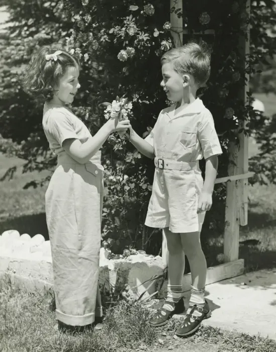 Framed Print : Boy (4-5) giving girl (4-5) flowers, (B&W)