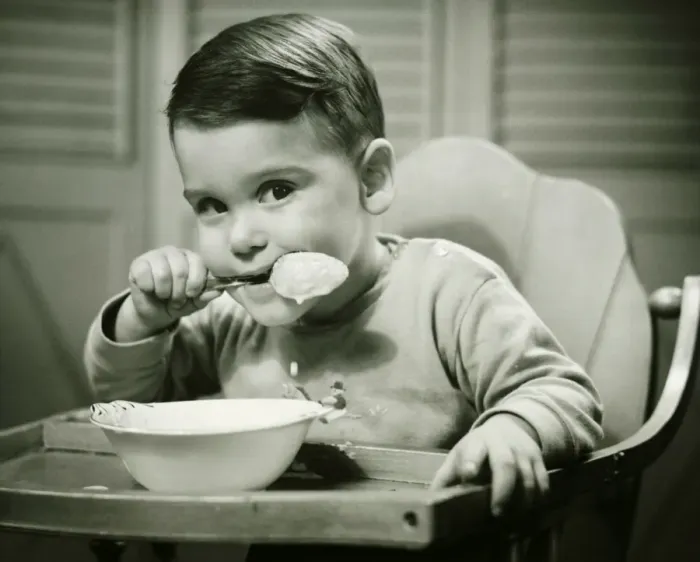 Framed Print : Boy (4-5) sitting in high chair, eating porridge, (B&W), portrait Framed Print : Boy (4-5) sitting in high chair, eating porridge, (B&W), portrait