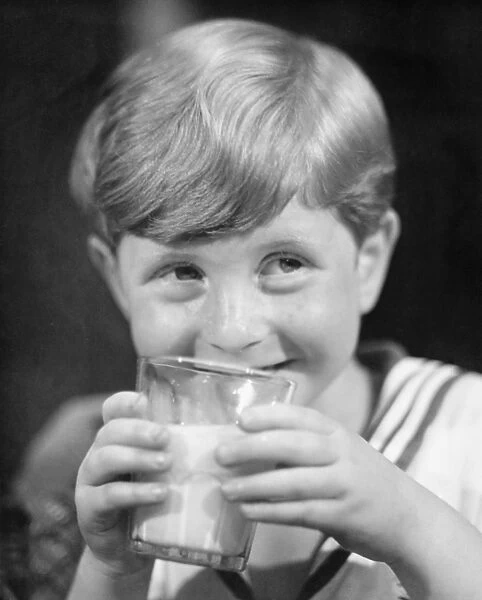 Boy (8-9) drinking milk from glass, smiling, (B&W)