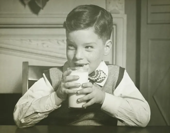 Framed Print : Boy (8-9) holding glass of milk, sitting at table, smiling, (B&W), close-up Framed Print : Boy (8-9) holding glass of milk, sitting at table, smiling, (B&W), close-up