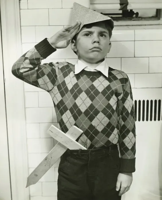 Framed Print : Boy (8-9) with wooden sword saluting indoors, (B&W) Framed Print : Boy (8-9) with wooden sword saluting indoors, (B&W)