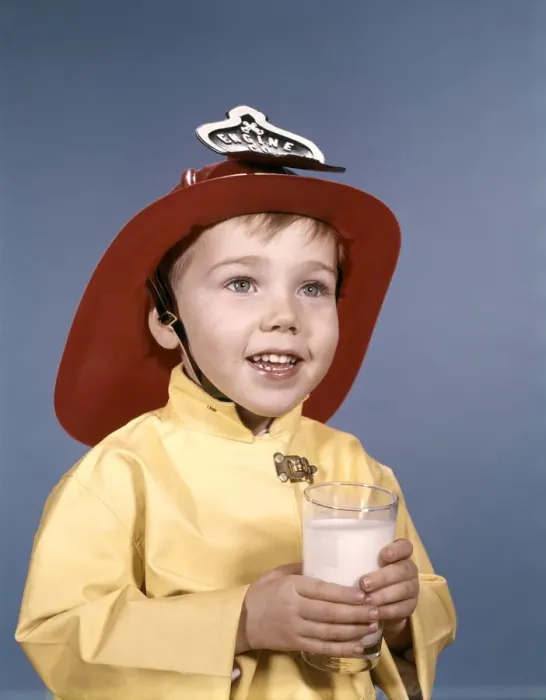 Framed Print : Boy in fireman costume, holding a glass of milk Framed Print : Boy in fireman costume, holding a glass of milk