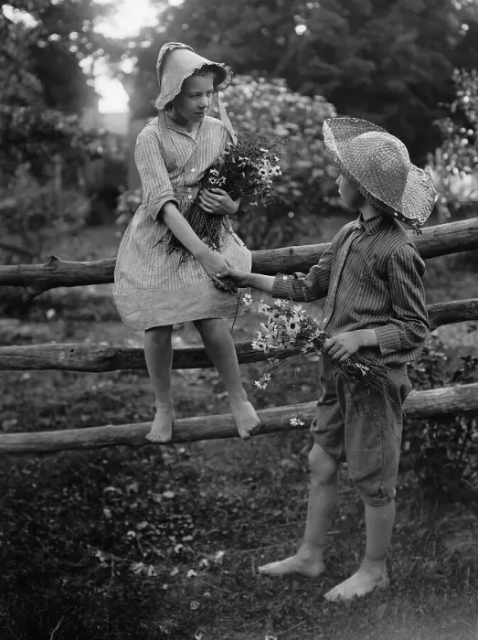 Framed Print : Boy Helping Girl (10-12 years) Climb Off of Fence. August 11, 1925