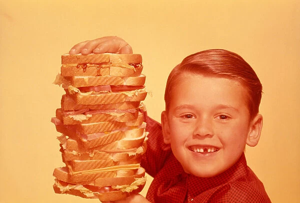 BOY HOLDING A FOOT HIGH SANDWICH, 1958