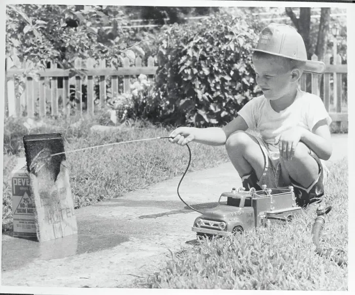Framed Print : Boy Hosing His Makeshift Toy as a Fireman