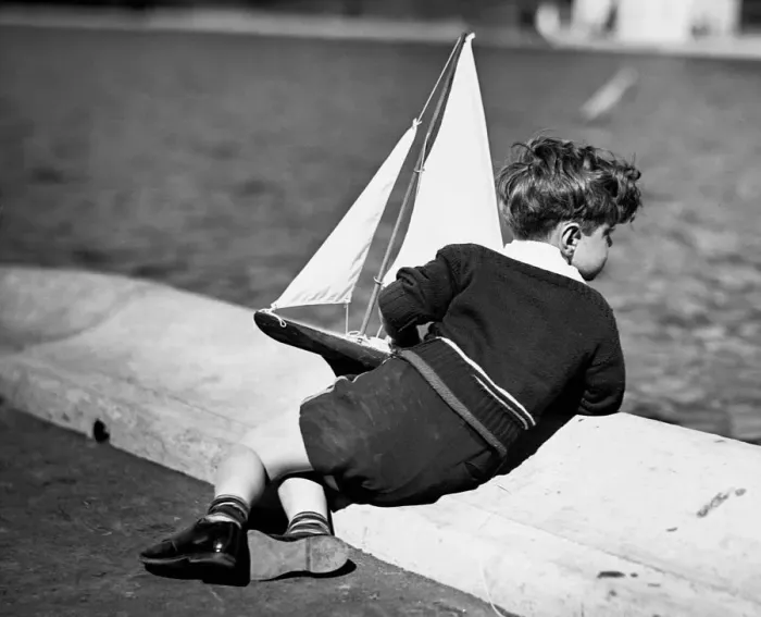 Framed Print : Boy playing with toy sailboat Framed Print : Boy playing with toy sailboat