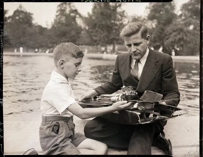 Framed Print : Boy Showing Wrecked Model Boat To Man Framed Print : Boy Showing Wrecked Model Boat To Man