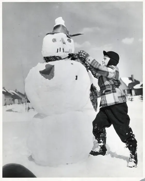 Framed Print : Boy Tying Scarf Around Snowman Framed Print : Boy Tying Scarf Around Snowman