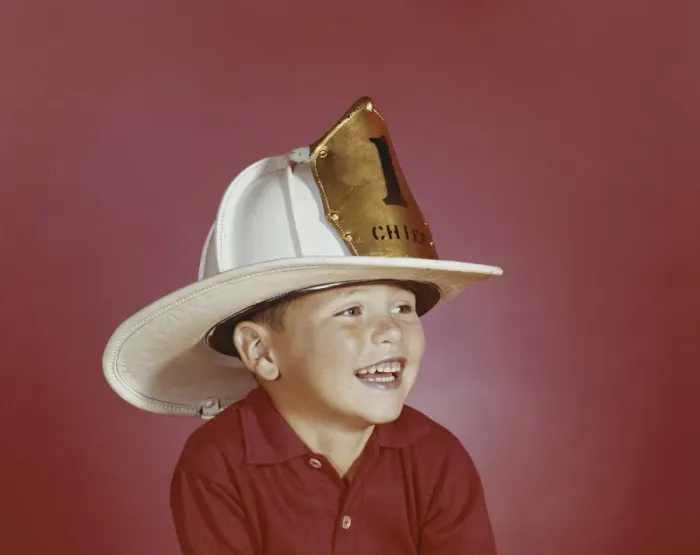 Framed Print : Boy wearing fireman hat, smiling, close-up Framed Print : Boy wearing fireman hat, smiling, close-up