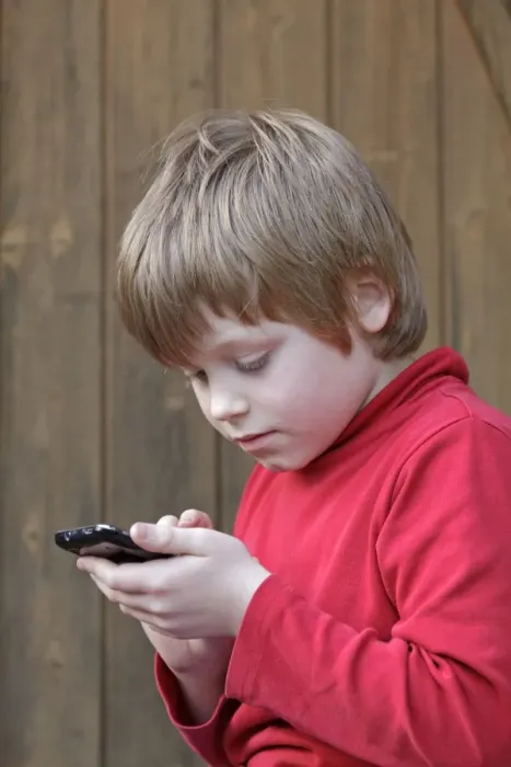 Framed Print : Boy writing a text message Framed Print : Boy writing a text message