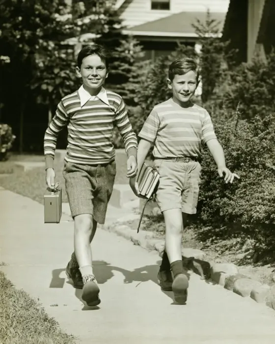 Framed Print : Two boys (10-11) walking side by side in suburbs, carrying books, (B&W) Framed Print : Two boys (10-11) walking side by side in suburbs, carrying books, (B&W)