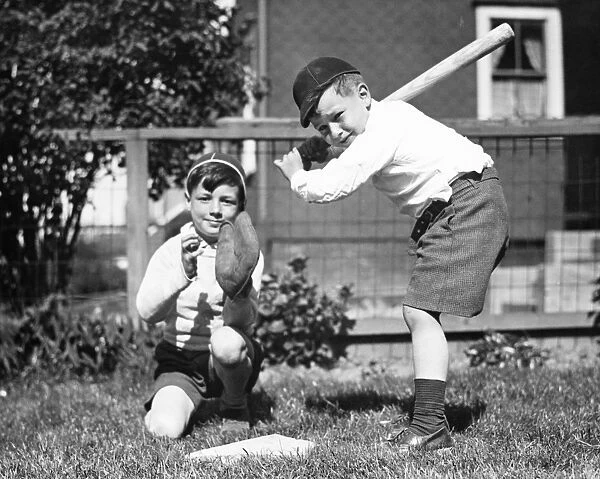 Two boys (6-7) playing baseball in garden, (B&W)