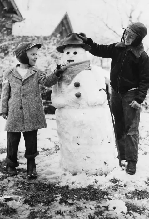 Framed Print : Two boys (8-9) posing with snowman