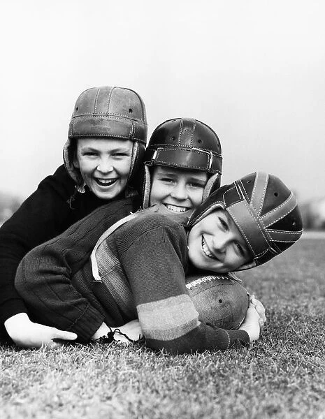 Three boys playing American football