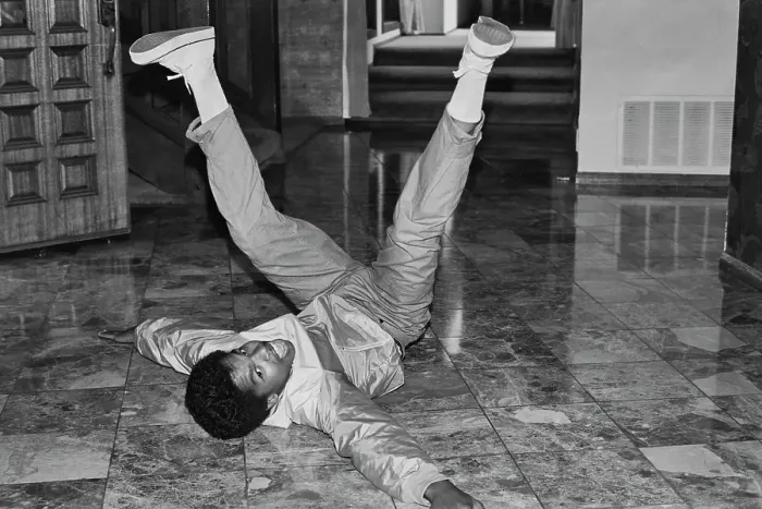 Framed Print : Breakin. A breakdancer with his legs in the air as he reclines on a marble-effect Framed Print : Breakin. A breakdancer with his legs in the air as he reclines on a marble-effect