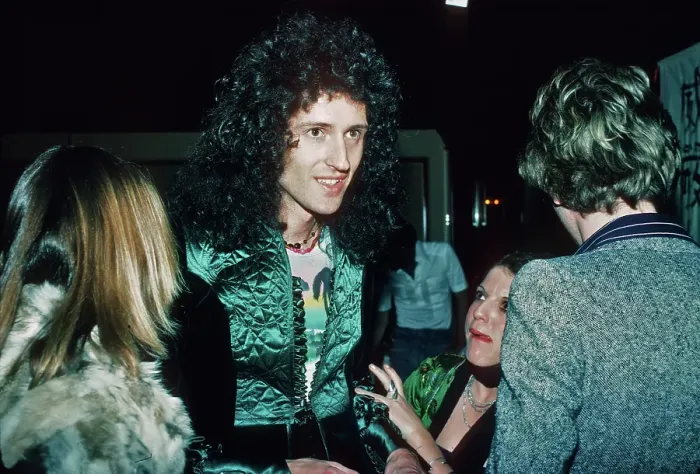 Framed Print : Brian May. Guitarist Brian May of British rock band Queen with fans at a party, March 1977