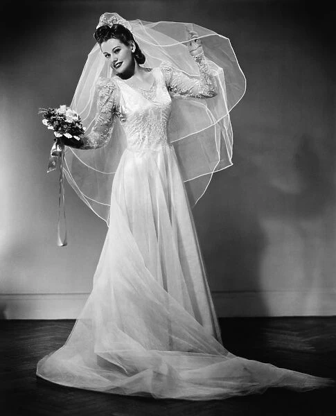Bride posing in studio, (B&W), portrait