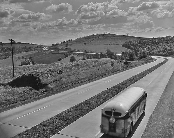 Bus Trip. A bus travelling along an empty highway circa 1960