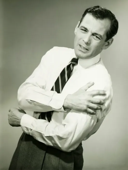 Framed Print : Businessman with aching arm in studio, (B&W) Framed Print : Businessman with aching arm in studio, (B&W)