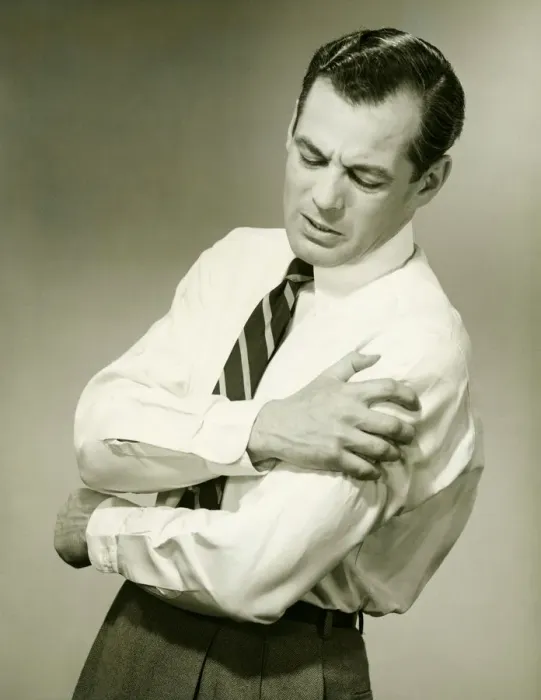 Framed Print : Businessman with aching arm in studio, (B&W) Framed Print : Businessman with aching arm in studio, (B&W)