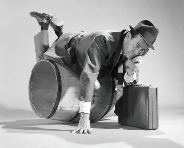 Framed Print : Businessman over a barrel, holding briefcase Framed Print : Businessman over a barrel, holding briefcase