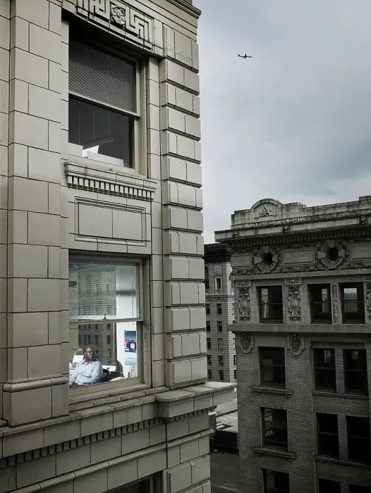 Framed Print : Businessman looking out of corner office