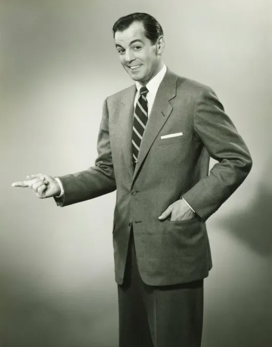 Framed Print : Businessman pointing sideways in studio, smiling, (B&W), portrait Framed Print : Businessman pointing sideways in studio, smiling, (B&W), portrait