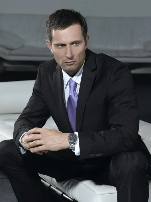 Framed Print : Businessman wearing a suit, sitting on a white sofa Framed Print : Businessman wearing a suit, sitting on a white sofa