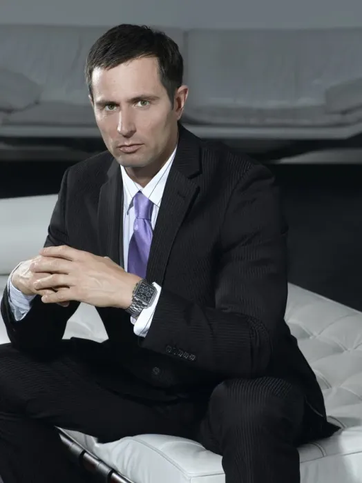 Framed Print : Businessman wearing a suit, sitting on a white sofa Framed Print : Businessman wearing a suit, sitting on a white sofa