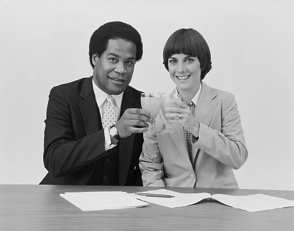 Businessman and woman toasting drink glass, smiling, portrait