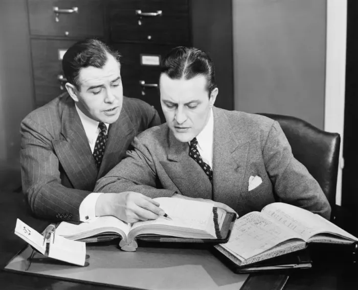 Framed Print : Two businessmen checking trading books, (B&W) Framed Print : Two businessmen checking trading books, (B&W)