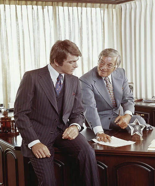 Two businessmen at desk looking at document