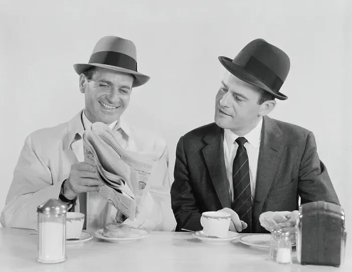 Framed Print : Two businessmen in suits and fedoras having breakfast at diner, looking at newspaper Framed Print : Two businessmen in suits and fedoras having breakfast at diner, looking at newspaper