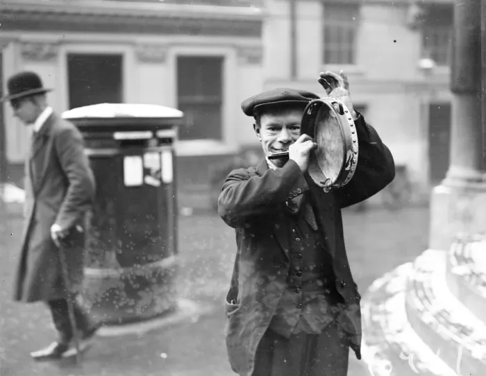 Framed Print : Busker. January 1929: A street musician entertains theatre queues outside a London theatre Framed Print : Busker. January 1929: A street musician entertains theatre queues outside a London theatre