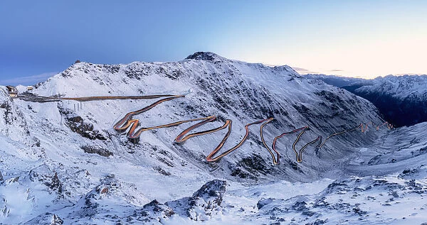 Car trails lights on bends of Stelvio Pass mountain road, South Tyrol, Italy