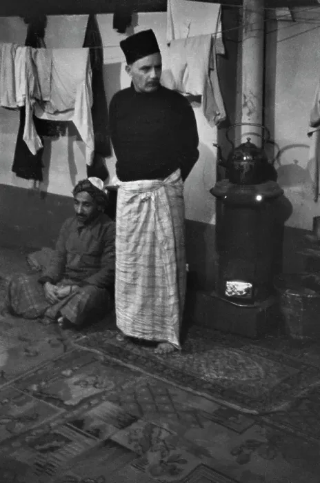 Framed Print : Cardiff. Two men warm themselves next to a wood-burning stove, Cardiff, 1939