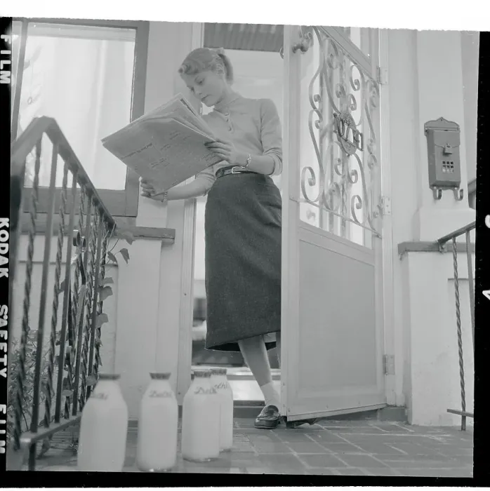 Framed Print : Carol Heiss Reading Newspaper and Standing in Her Doorway Framed Print : Carol Heiss Reading Newspaper and Standing in Her Doorway