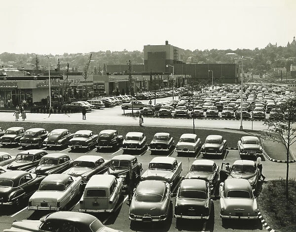 Cars parked on lot at shopping centre, elevated view (B&W)