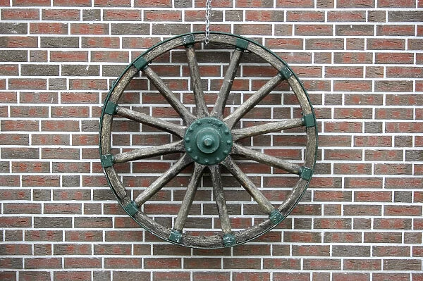 Cart wheel on a clinker brick facade in East Friesland, Lower Saxony, Germany, Europe
