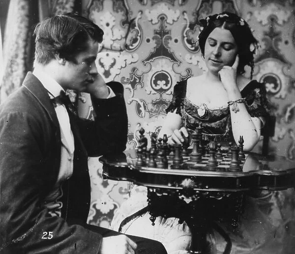 Checkmate. circa 1865: A young man waits for a young woman to make her move at chess