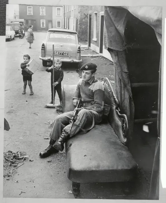 Framed Print : Children Sweeping Street While Soldier Rests Framed Print : Children Sweeping Street While Soldier Rests