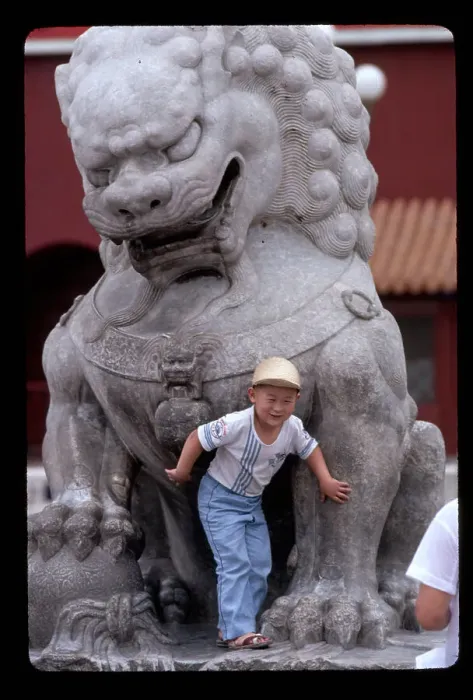 Framed Print : Chinese Boy Poses with Statue of Lion Framed Print : Chinese Boy Poses with Statue of Lion