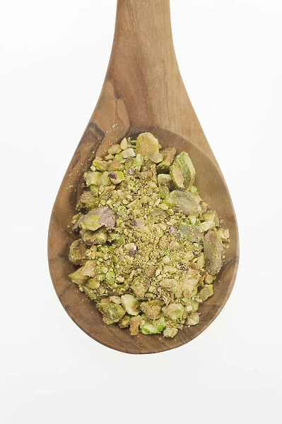 Chopped Pistachio (Pistacia vera) nuts on an olive wood spoon